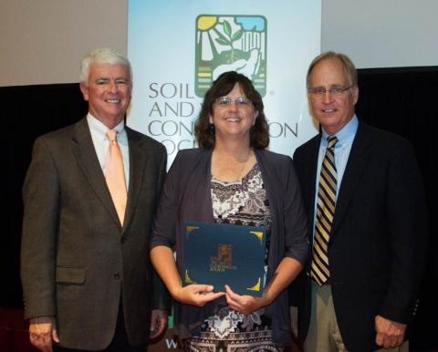 NRCS Resource Conservationist Claudia Stevenson receiving the International SWCS Commendation Award at the international meeting in July from (left) association executive director Jim Guilliford and association president Jon Scholl.