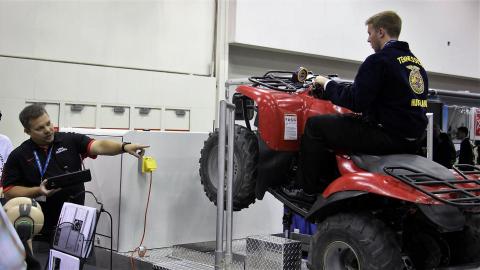 图1。亚伦·约德在全国FFA大会上使用ATV模拟器提供安全培训。Yoder将成为青年拖拉机安全和危险职业课程的讲师之一。