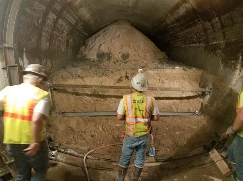 工人们正在检查两条隧道中较小隧道坍塌的地点。